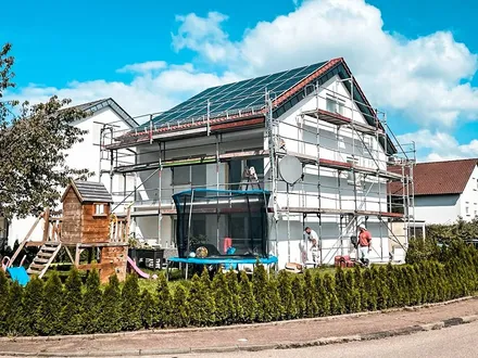 A.D.I.-Team dämmt ein eingerüstetes Einfamilienhaus, Wärmedämmverbundsystem in Arbeit