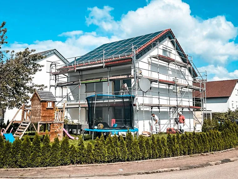 A.D.I.-Team dämmt ein eingerüstetes Einfamilienhaus, Wärmedämmverbundsystem in Arbeit