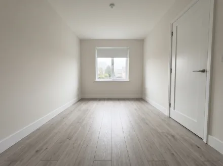 Fertig verlegter heller Laminatboden in einem leeren Zimmer